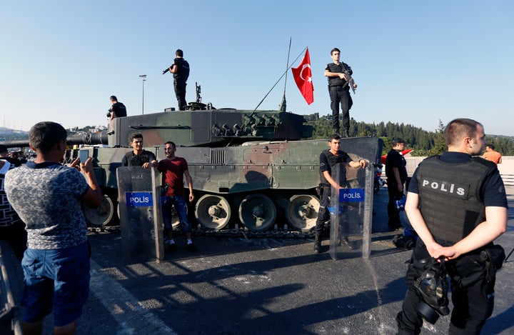 People pose with policemen after troops involved in the coup surrendered on the Bosphorus Bridge in Istanbul, Turkey July 16, 2016.