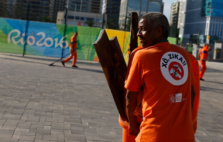 A workers wears a sign which reads "Shoo Zika!" in Portuguese on his back in the Olympic park.