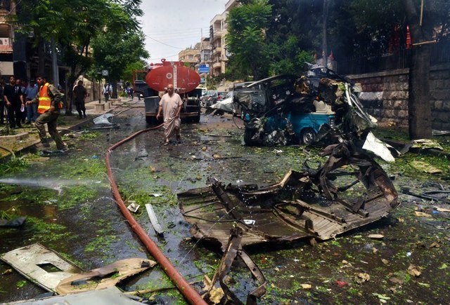 Syrian citizens and firefighters gather at the scene where one of several rockets hit the Dubeet hospital in the central neighborhood of Muhafaza in Aleppo, Syria on May 3, 2016.