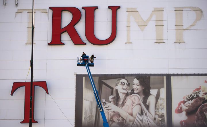 Workers remove letters from the Trump Plaza Casino signage in Atlantic City, New Jersey, in 2014.