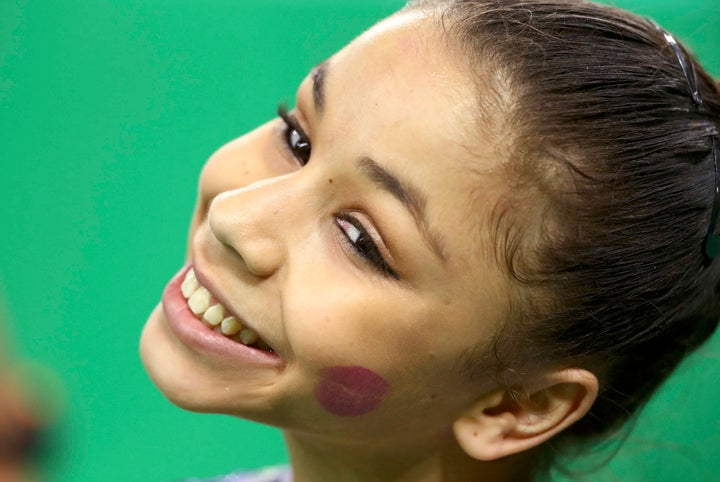 Flavia Saraiva of Brazil smiles with a lipstick kiss stain on her cheek during the women's qualifications.