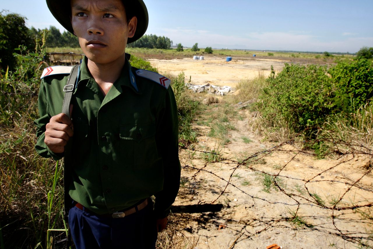 A Vietnamese soldier guards the contaminated site at the edge of the Da Nang Airfield on July 1, 2009 in Da Nang, Central Vietnam. During the Vietnam War, the U.S. military stored more than four million of gallons of herbicides, including Agent Orange, at the military base that is now a domestic and military airbase.
