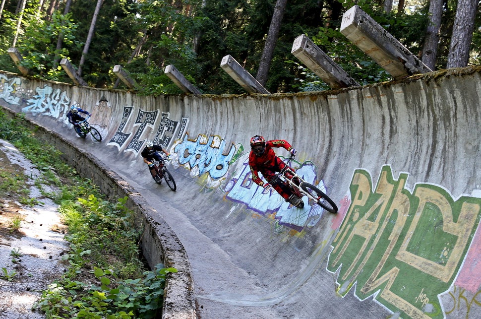 Downhill bikers Kemal Mulic (R-L), Tarik Hadzic and Kamer Kolar train on the disused bobsled track from the 1984 Sarajevo Win