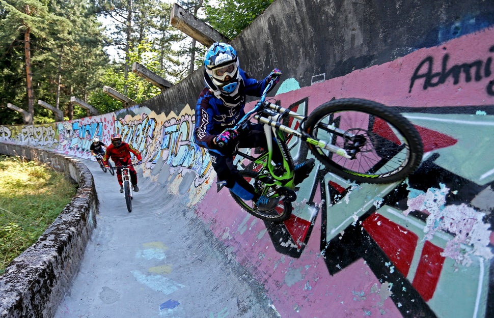 Downhill bikers Kemal Mulic (C), Tarik Hadzic (L) and Kamer Kolar train on the disused bobsled track from the 1984 Sarajevo W