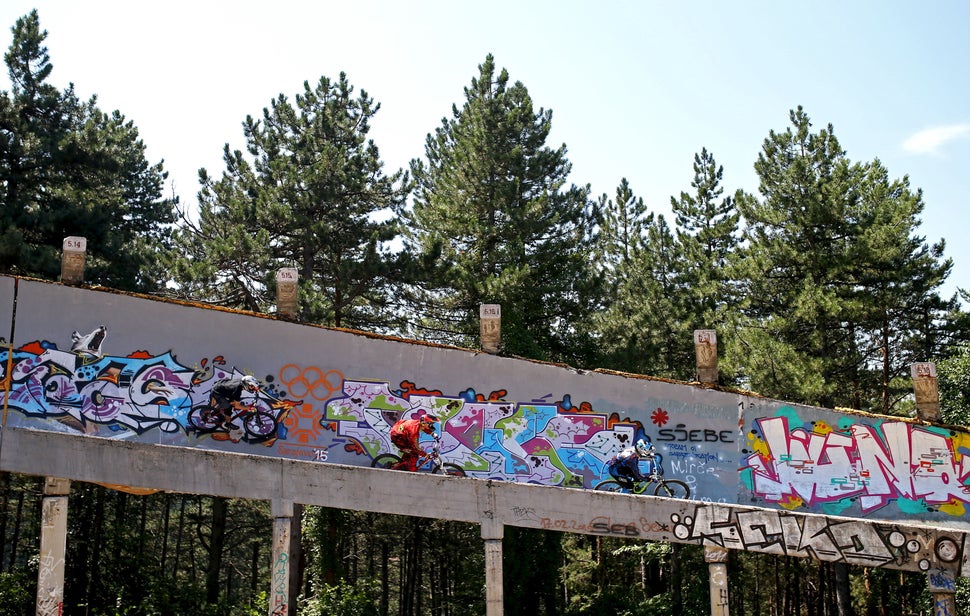 Downhill bikers Tarik Hadzic (L-R), Kemal Mulic and Kamer Kolar train on the disused bobsled track from the 1984 Sarajevo Win