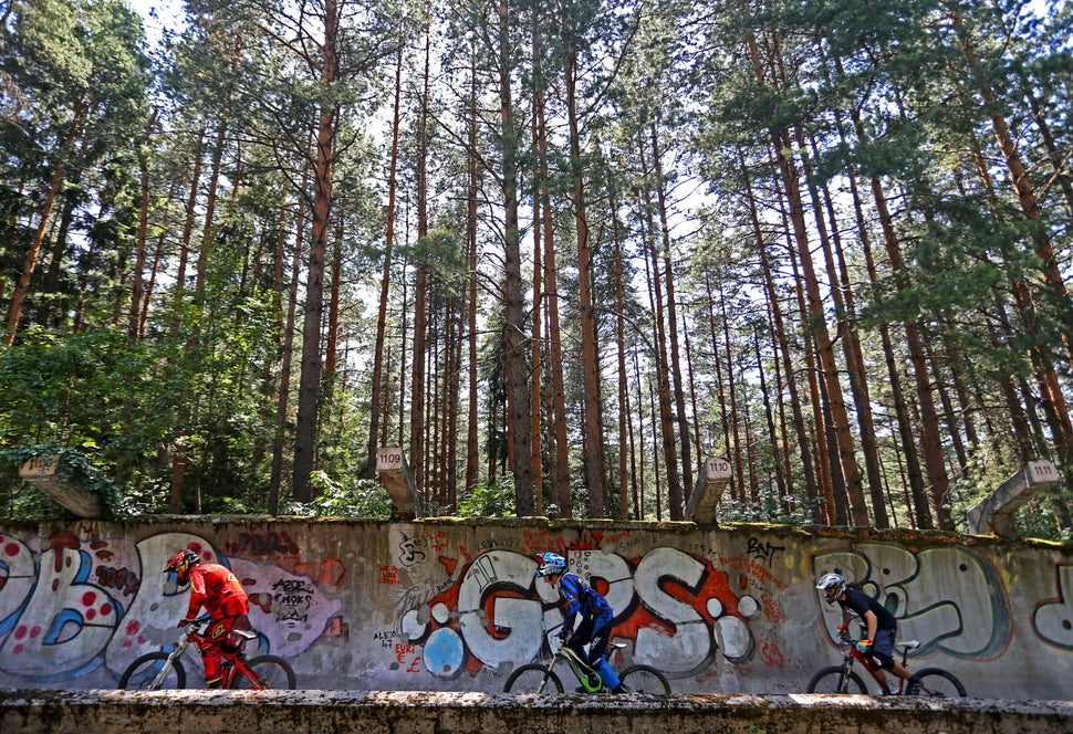 Downhill bikers Kemal Mulic (L-R), Kamer Kolar and Tarik Hadzic train on the disused bobsled track from the 1984 Sarajevo Win