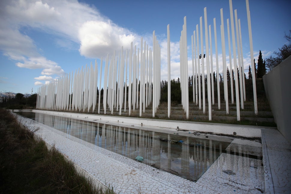 Unused flagposts stand in front of a litter-strewn water feature in the 2004 Olympic Games Complex in February 2012 in Athens