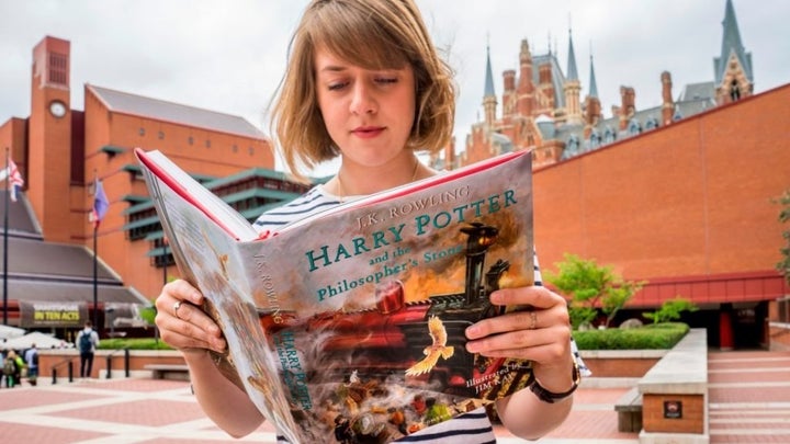 British Library employee reading <em>Harry Potter and the Philosopher's Stone</em>. Courtesy of photographer Tony Antoniou and the British Library.