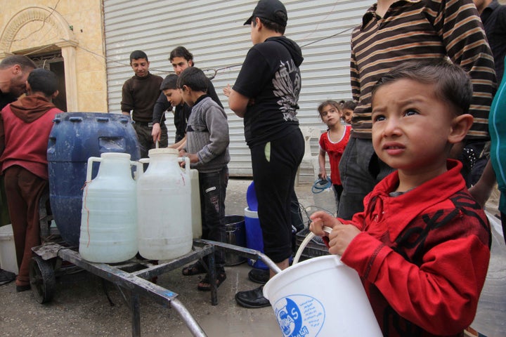 Residents and children wait to collect water in Aleppo, April 2, 2013. Around Syria, water shortages are worsening and supplies are sometimes contaminated, putting children at increased risk of diseases. REUTERS/Giath Taha