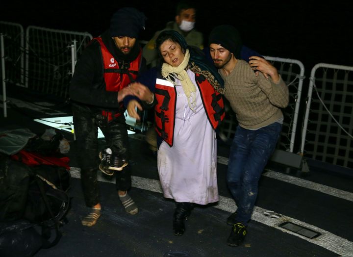 Turkish coast guards pull an Afghan refugee, 8.5 months pregnant, into a Coast Guard ship, during a rescue operation for the refugees trying to reach Greece through the Aegean Sea with an overloaded inflatable boat.