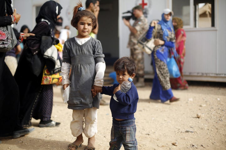 Syrian refugees wait to board a Jordanian army vehicle after crossing into Jordanian territory with their families.