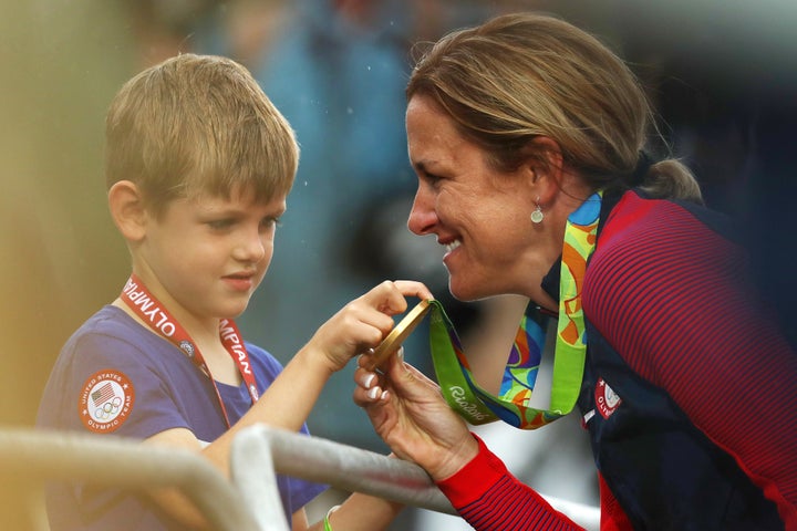 Kristin Armstrong shows her medal to her son, Lucas, after the medal ceremony.