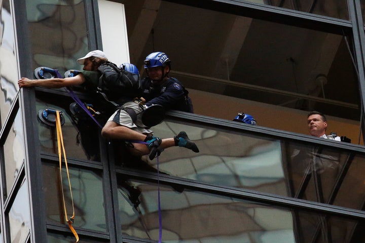 Officers from the NYPD embrace a man to stop him from climbing the outside of Trump Tower in New York, U.S., August 10, 2016. (REUTERS/Lucas Jackson)