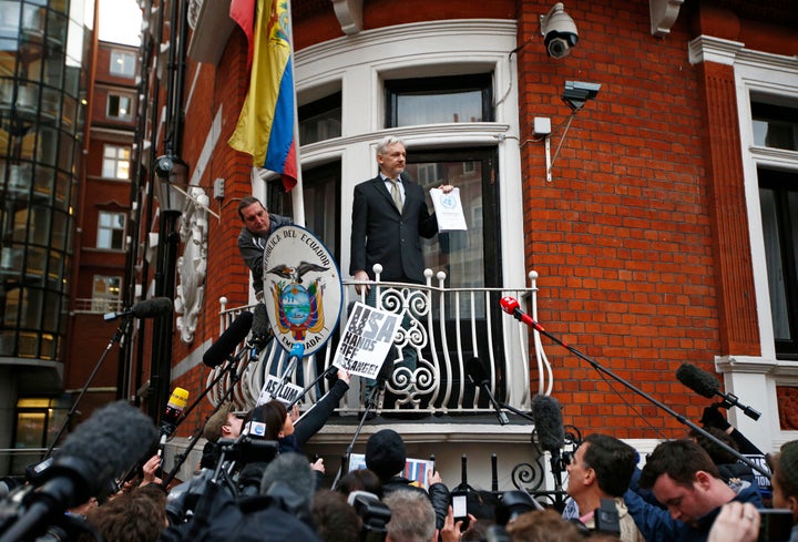 WikiLeaks founder Julian Assange holds a copy of a U.N. ruling as he makes a speech from the balcony of the Ecuadorian Embass