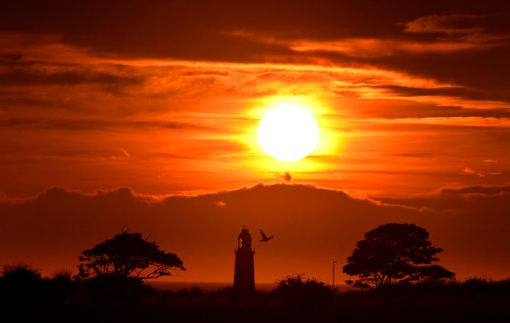 The sun rises over Whitley Bay with the top of St Mary's lighthouse visible