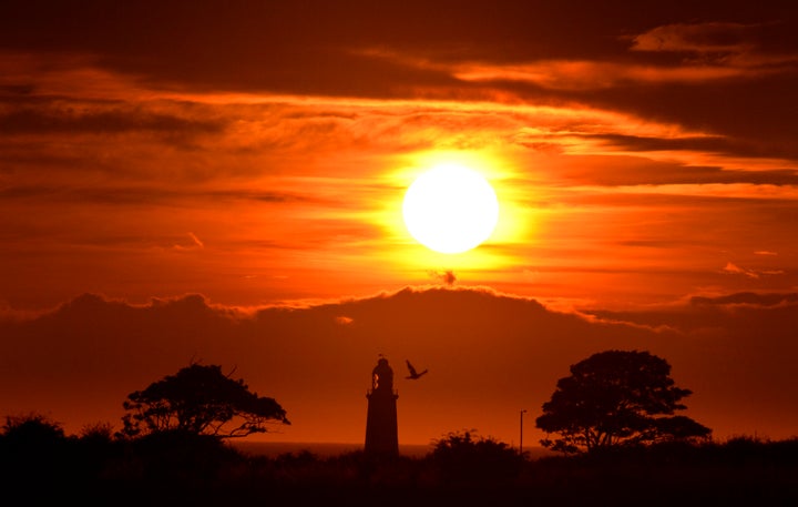 The sun rises over Whitley Bay with the top of St Mary's lighthouse visible