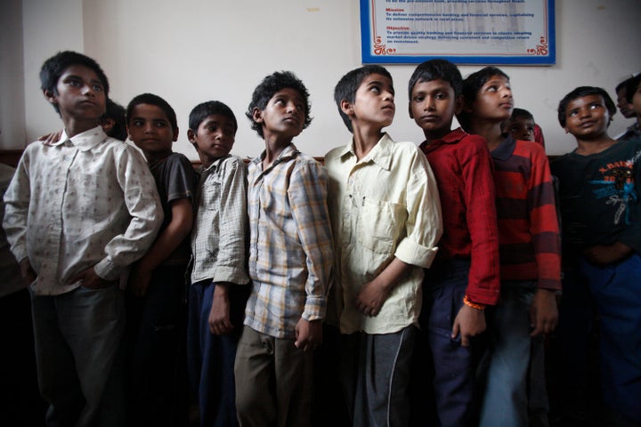Children queue up for a medical examination after being rescued from a sari embroidery factory, with the help of Nepalese pol