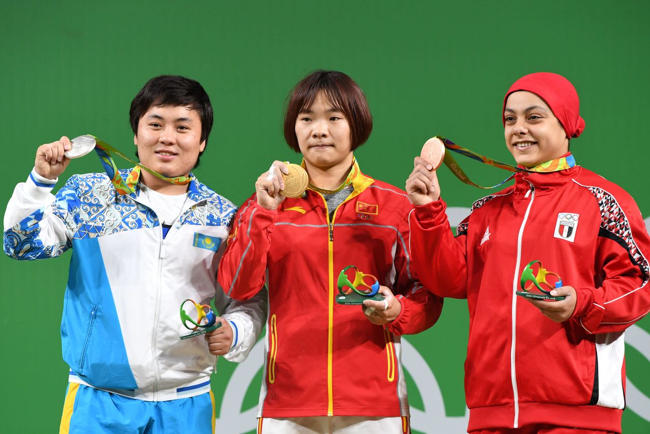 Sara Ahmed, right, stands on the podium with China's Xiang Yanmei, center, and Kazakhstan's Zhazira Zhapparkul, left.