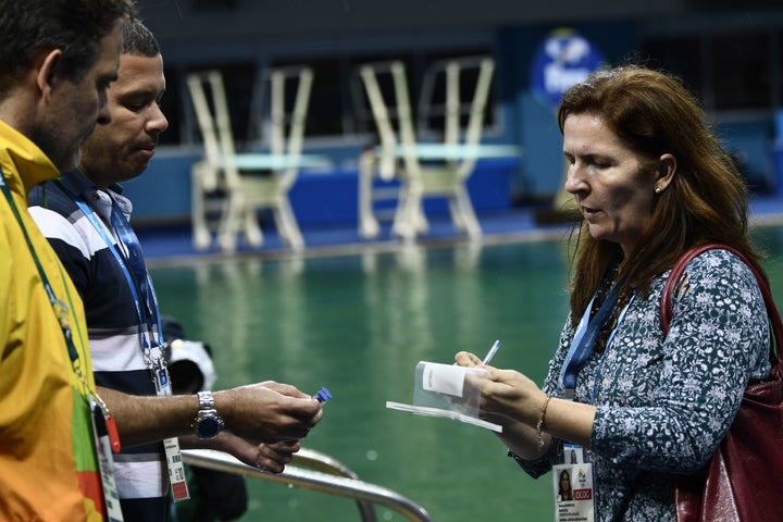 Experts get ready to take samples of the diving pool water at the Maria Lenk Aquatics Stadium in Rio de Janeiro on