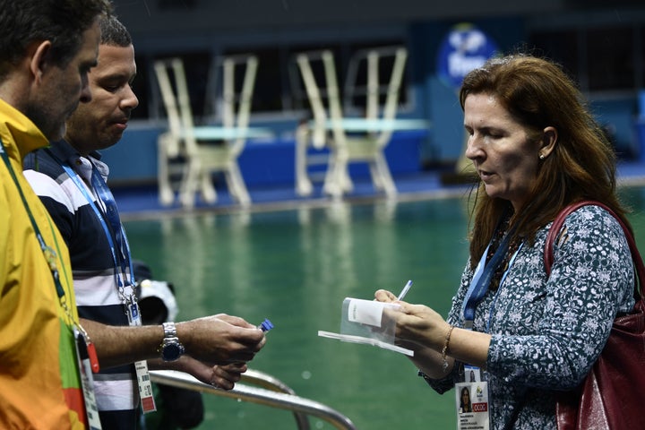 Experts get ready to take samples of the diving pool water at the Maria Lenk Aquatics Stadium in Rio de Janeiro on August 10, 2016.