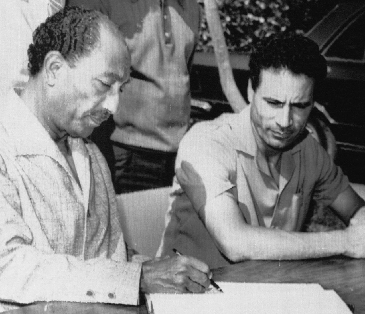 Sadat, left, and Gaddafi look over a communiqué after agreeing to merge their two countries on Sept. 7, 1973.