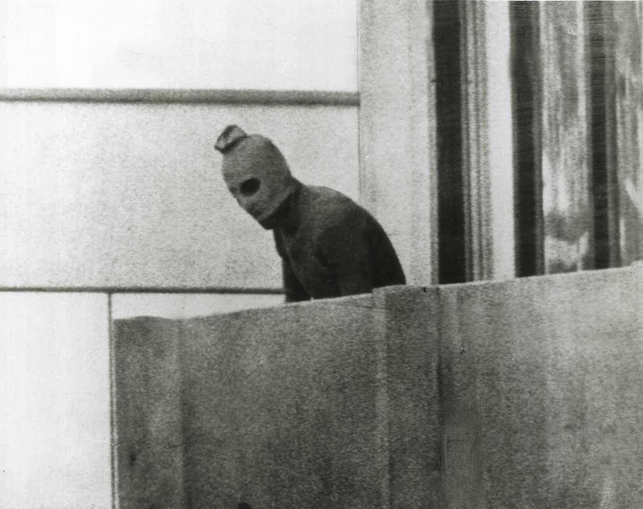 A Palestinian terrorist peers over the balcony of a room in the Olympic Village, where Israeli athletes were being held hostage, in Munich on Sept. 5, 1972.