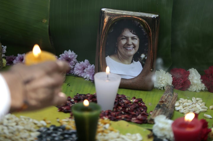 An activist places a candle in an offering to slain Honduran indigenous environmentalist Berta Cáceres. U.S. aid to Honduras is coming under scrutiny because of the assassination.