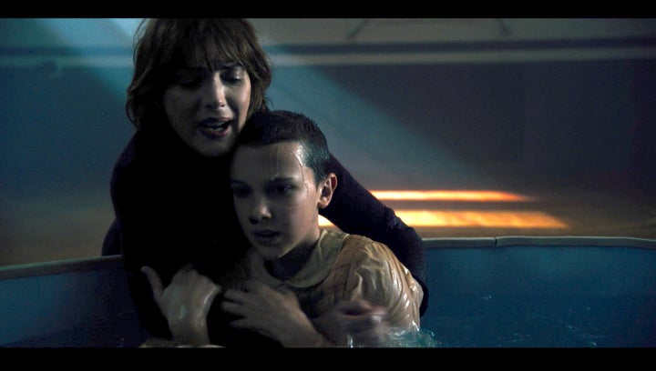 "The Bathtub" - Joyce Byers (Winona Ryder) and Eleven (Millie Bobby Brown) cling to one another in Episode 7 of the scifi mystery-drama 'Stranger Things'.