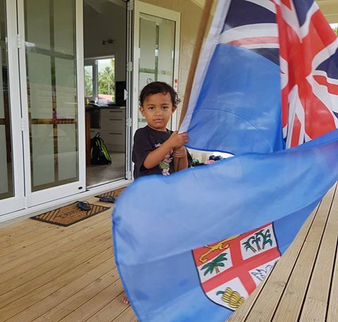 A Samoan child with a Fiji flag in Cook Islands.