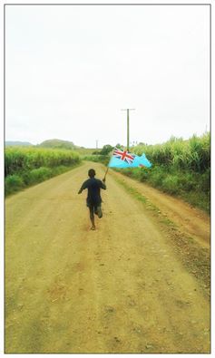 This child running to the closest television half a mile away to cheer on the Fijians.