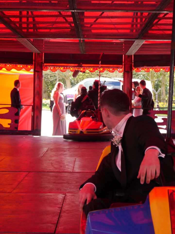 Lawrence waits for his bride to ride down the aisle in a bumper car.