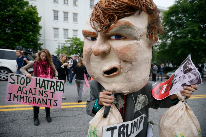 A masked protester demonstrates outside Republican National Committee (RNC) headquarters, where Republican U.S. presidential candidate Donald Trump was meeting with House Speaker Paul Ryan (R-WI) and RNC Chairman Reince Priebus in Washington, U.S., May 12, 2016.