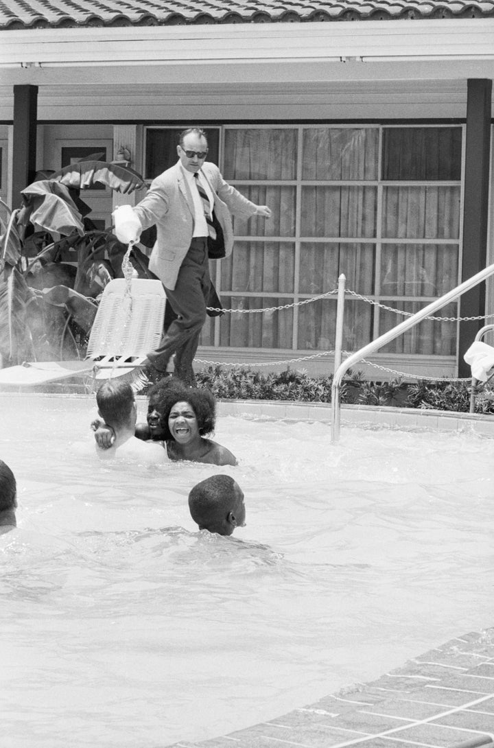 Protesters demonstrating in the swimming pool of the Monson Motor Lodge in Saint Augustine, Florida, scream as motel manager James Brock dumps "muriatic acid" into the water.