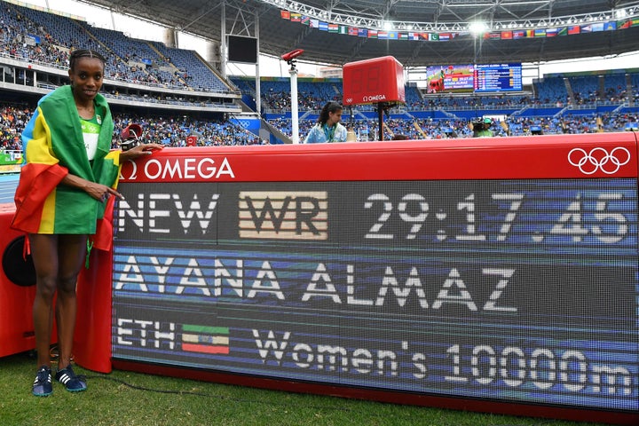 Ethiopia's Almaz Ayana celebrates next to a board displaying her new world record for the women's 10,000 meters at the Rio Olympics. August 12th, 2016.