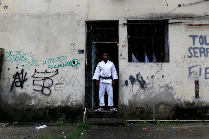 Popole Misenga, a refugee from the Democratic Republic of Congo and a judo athlete, poses at the entrance of his home in a sl