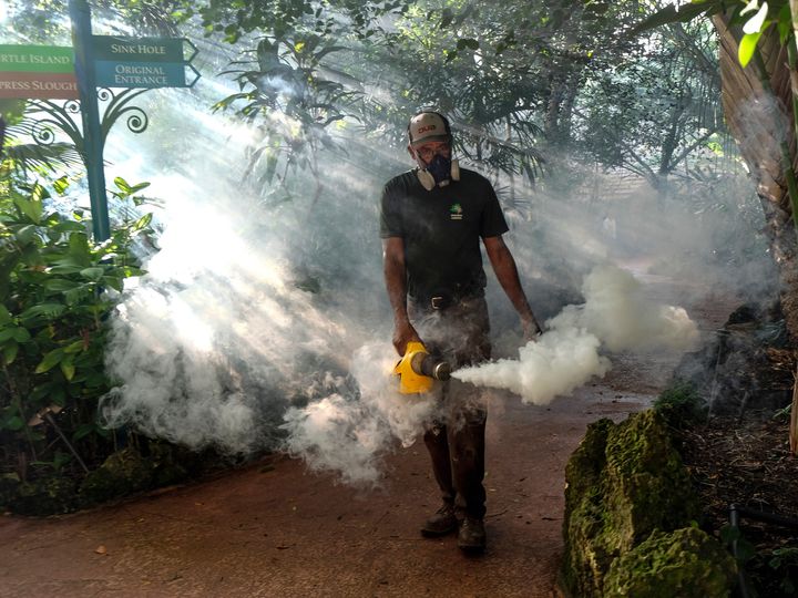 Fran Middlebrooks uses a blower to spray pesticide to kill mosquitos Aug. 4, 2016 in Miami, as Miami Dade county fights to control the Zika virus outbreak.
