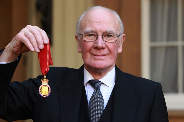 Sir Menzies Campbell holds his medal after being made a Companion of Honour by the Duke of Cambridge.