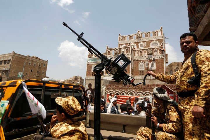 A soldier holds a machine gun mounted on a police truck outside Yemen's parliament during the first parliament session s