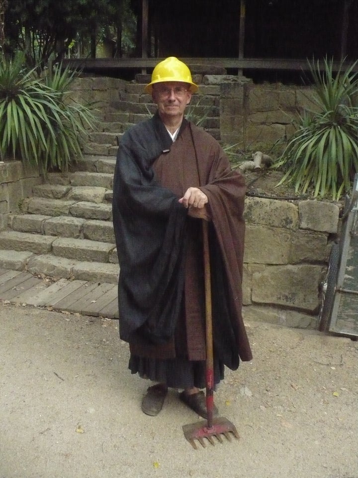 Abbot Steve posing in his robes with fire gear after the 2008 Basin Complex fire.