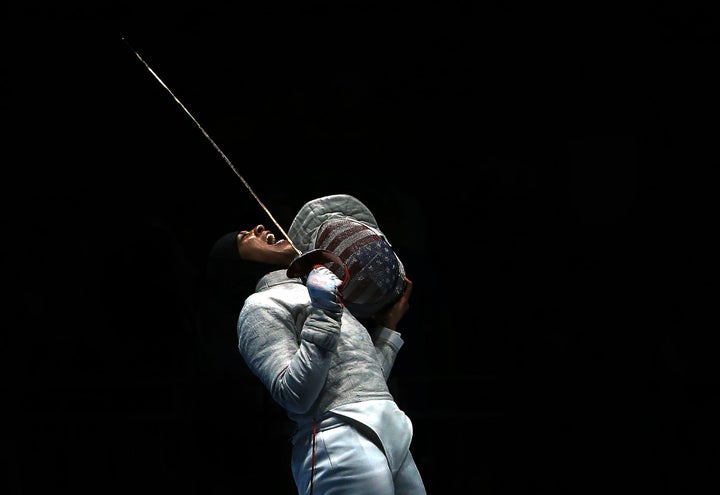 Ibtihaj Muhammad celebrates a point over Ekaterina Dyachenko of Russia in the Women's Sabre Team Semifinals of the Rio Olympic Games on August 13, 2016