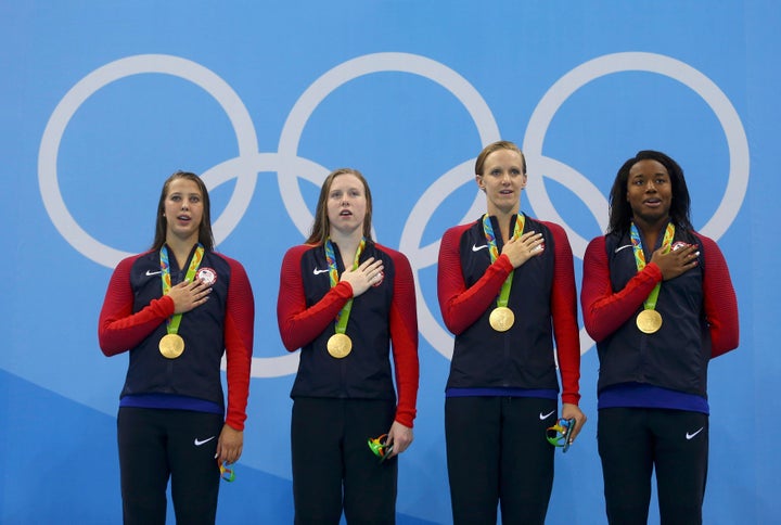 Gold medallists Kathleen Baker (USA) of USA, Lilly King (USA) of USA, Dana Vollmer (USA) of USA and Simone Manuel (USA) of USA stand to attention after receiving their medals.