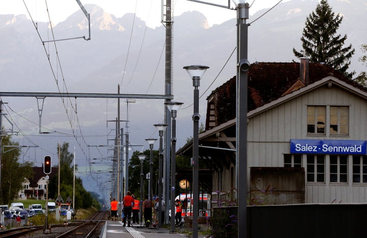 Workers clean a platform after a 27-year-old Swiss man's attack on a Swiss train at the railway station in the town of Salez,