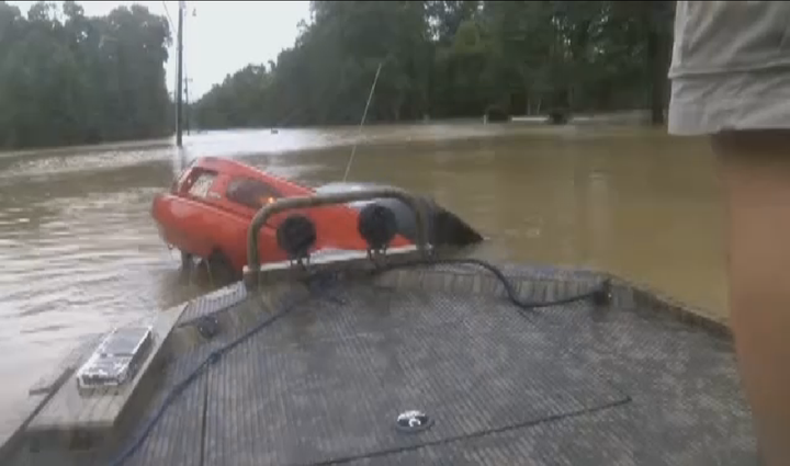 Several boaters are seen coming upon a sinking car following historic flooding across Louisiana.