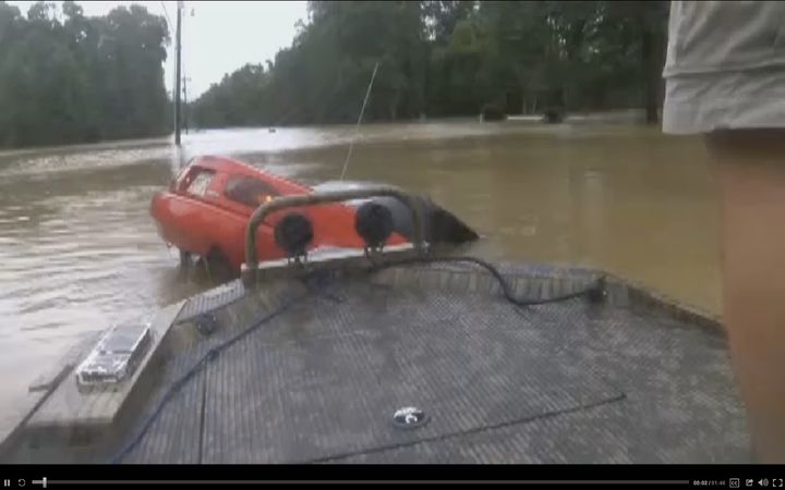 Several boaters are seen coming upon a sinking car following historic flooding across Louisiana.