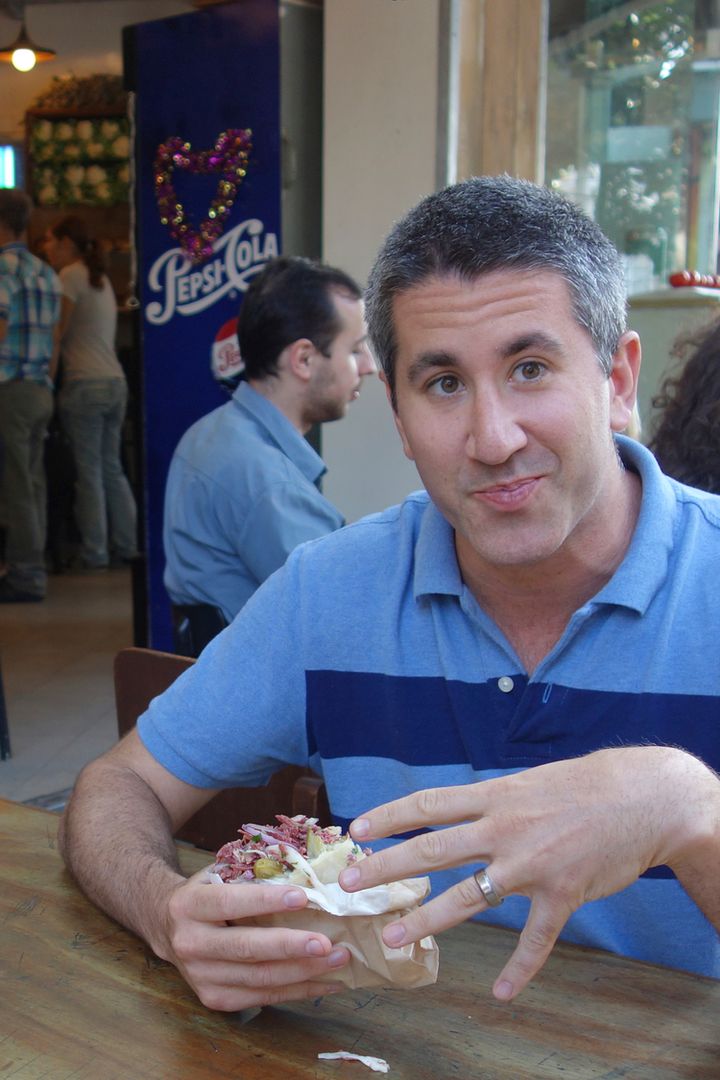 Chef Michael Solomonov (seen eating a corned beef pitasandwich) in a scene from In Search of Israeli Cuisine