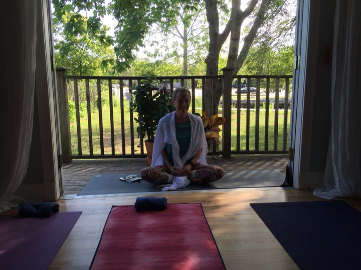 Abby Vakay (founder and owner of Hamptons Yoga) is perched on the terrace before the Jivamukti Open yoga class.
