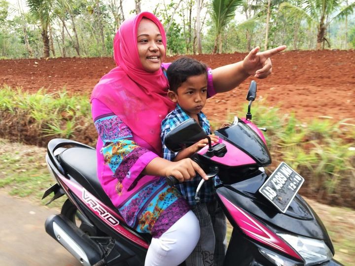 Trisuprapti rides her motorcycle with her son. She says she felt she had nowhere to turn when she got pregnant.