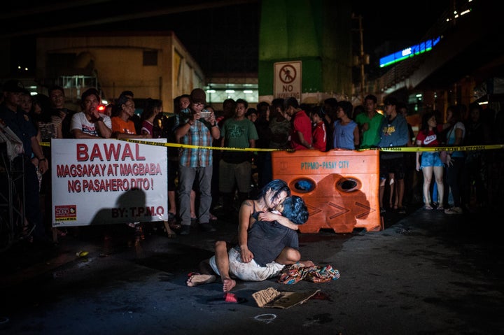 Jennilyn Olayres clutches the body of her husband, Michael Siaron, after he was shot and killed on a main street in Mani