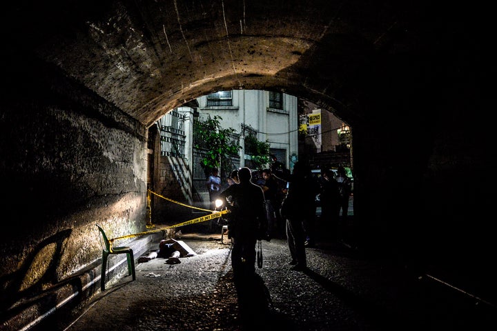 Police and media inspect the corpse of a suspected drug pusher and victim of a vigilante-style execution under a bridge in Manila, Philippines, July 31, 2016.