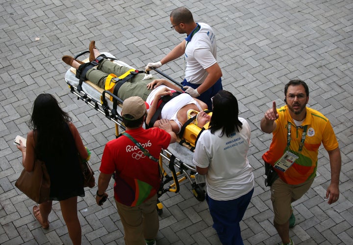 A woman is transported to an ambulance after being hit by an overhead television camera that fell and injured two people near the Olympic Park